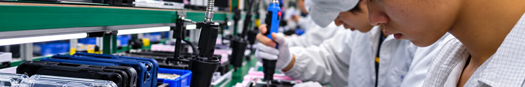 Ouvriers assemblant des coques de téléphone sur une ligne de production